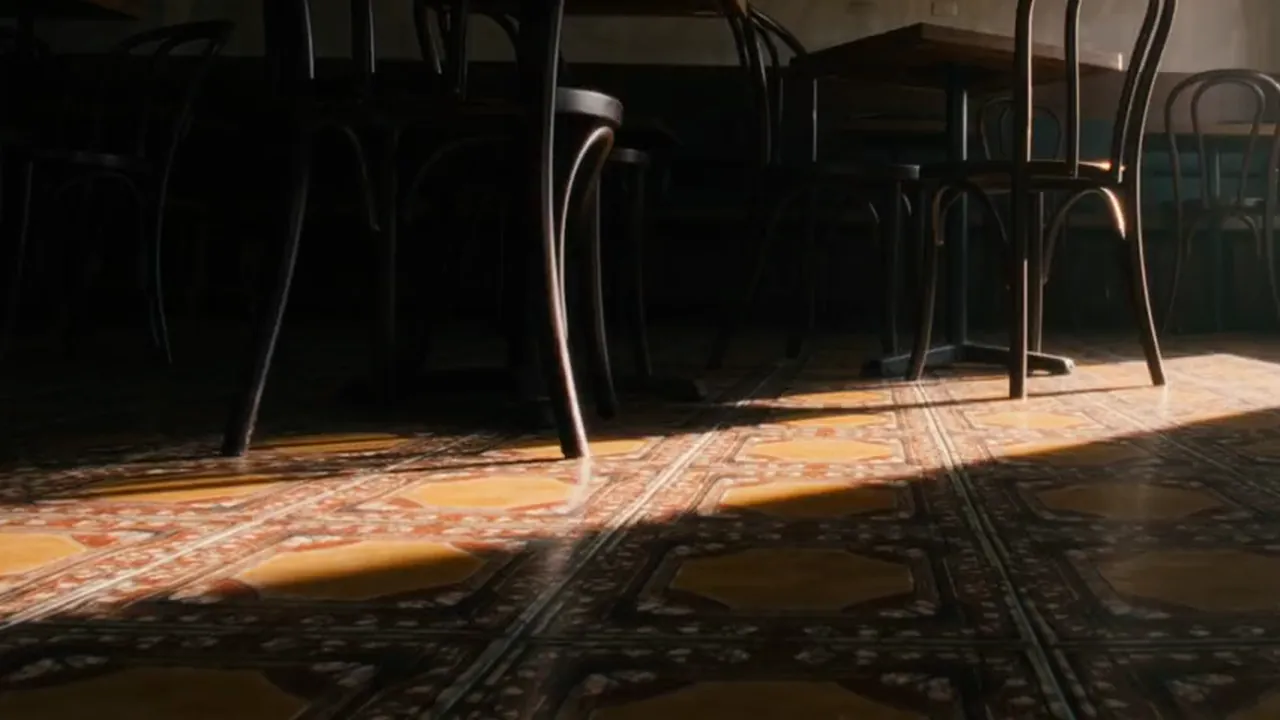 Window light raking across the patterned floor tiles.